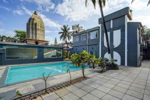 an exterior view of a house with a swimming pool at Hotel Plaza Inn by Rio in Calangute