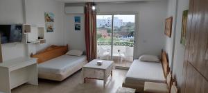 a small room with two beds and a balcony at Apartment in LTI Mahdia Beach Hotel in Mahdia