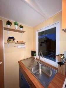 une cuisine avec un évier et une fenêtre dans l'établissement Fonte Retreat - Holiday Home, à Sandim