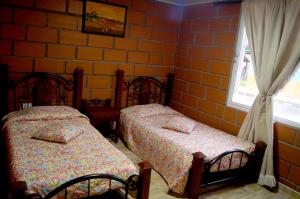 een slaapkamer met 2 bedden en een raam bij Casa Campestre la Guacamaya in San Félix