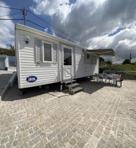 een witte trailer geparkeerd op een bakstenen patio bij Fonte Retreat - Holiday Home in Sandim