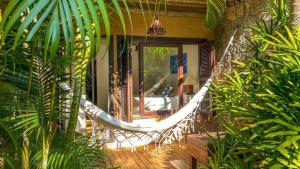 a porch with a hammock on a house at Morada da Praia do Rosa Pousada in Praia do Rosa