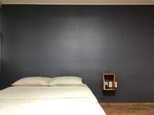 ein Schlafzimmer mit einem weißen Bett und einer schwarzen Wand in der Unterkunft Jo Eun Jip Guesthouse in Mokpo