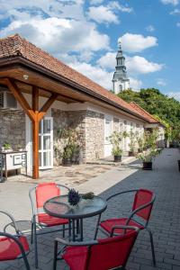 un patio con mesa y sillas y un edificio en JóKissHely Vendégház en Erdőbénye