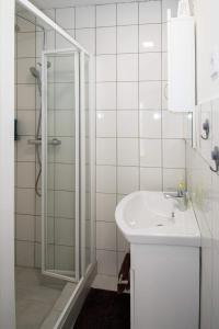 a white bathroom with a sink and a shower at JóKissHely Vendégház in Erdőbénye