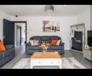 ein Wohnzimmer mit einem Sofa und einem Tisch in der Unterkunft Marston 5 Bedroom Home With Parking Near NEC & BHX in Marston Green