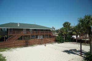 a house on the beach with a volleyball court in front at Cottages Christian Retreat in Panama City Beach