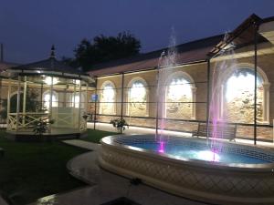 a fountain in front of a building with a building at HOTEL DaMir in Samarkand