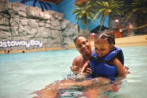 un uomo e una bambina in una piscina di Castaway Bay by Cedar Point Resorts a Sandusky