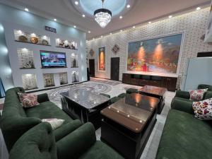 a living room with green furniture and a large painting at HOTEL DaMir in Samarkand