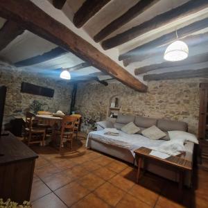 a living room with a bed and a table at La casa del Herrero in Villanueva de Viver