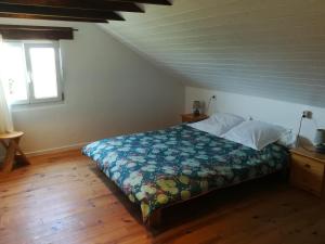 a bedroom with a bed with a quilt on it at TY MERVENT, l'océan à 500 m in Saint-Jean-Trolimon