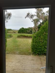 an open door with a view of a yard at TY MERVENT, l'océan à 500 m in Saint-Jean-Trolimon