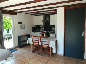 a kitchen and dining room with a table and chairs at TY MERVENT, l'océan à 500 m in Saint-Jean-Trolimon