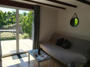 a room with a bed and a table and a window at TY MERVENT, l'océan à 500 m in Saint-Jean-Trolimon