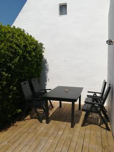 a picnic table and two chairs on a deck at TY MERVENT, l'océan à 500 m in Saint-Jean-Trolimon
