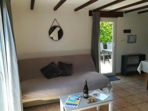a room with a bed and a table with a bottle of wine at TY MERVENT, l'océan à 500 m in Saint-Jean-Trolimon