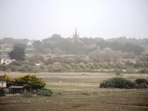 a view of a field with a church in the distance at TY MERVENT, l'océan à 500 m in Saint-Jean-Trolimon