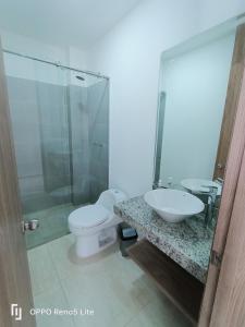 y baño con aseo, lavabo y ducha. en Casa vacacional condominio bambú, en Carmen de Apicalá