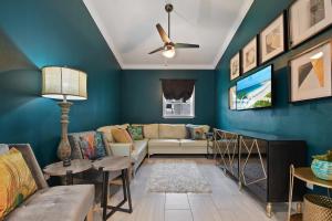 - un salon avec des murs bleus et un canapé dans l'établissement Peacock Suite. Centrally Located. Amazing Outdoor Space., à Orlando