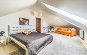 a bedroom with a bed and an orange chair at Awesome Home In Kobylanka With Wifi in Kobylanka