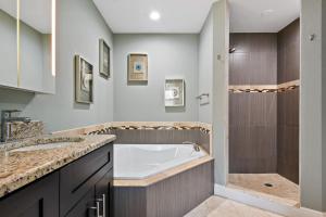 La salle de bains est pourvue d'une baignoire et d'une douche. dans l'établissement Peacock Suite. Centrally Located. Amazing Outdoor Space., à Orlando
