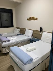 a hospital room with three beds in it at AVENIDA HOTEL DE RESENDE in Resende