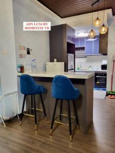 duas cadeiras azuis sentadas num balcão numa cozinha em Lovely Luxury 3 Br 2Bath @Vista Bangi em Kajang