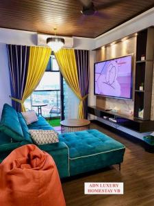 uma sala de estar com um sofá e uma televisão de ecrã plano em Lovely Luxury 3 Br 2Bath @Vista Bangi em Kajang