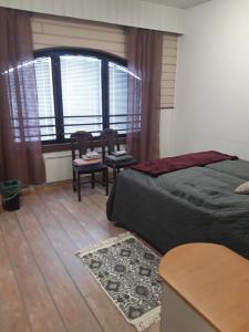 a bedroom with a bed and chairs and a window at Jaalan Tienristi in Kouvola