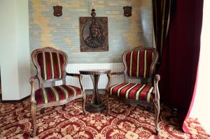 two chairs and a table in a room at Castel Transilvania in Baia Mare