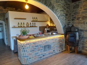 a woman in a kitchen with a brick wall at I TRE GRAPPOLI in Corniglia
