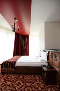 a bedroom with a bed and a red wall at Castel Transilvania in Baia Mare