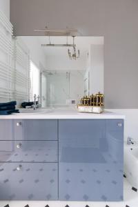 uma casa de banho branca com um lavatório e um espelho em Bea Garden Home - dwie sypialnie i taras em Elblag