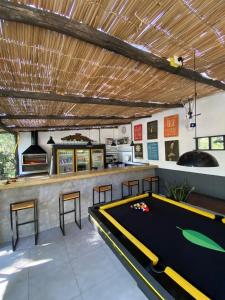 una sala de billar con una mesa de billar y un bar en Foresthouse, en Florianópolis