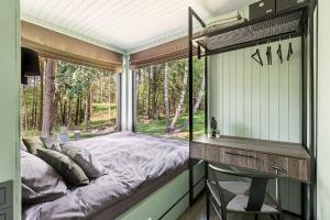 Schlafzimmer mit einem Bett, einem Schreibtisch und einem Fenster in der Unterkunft BRENDIS -'Virš Ąžuolų' - Forest SPA - FREE jacuzzi in Paplatelė