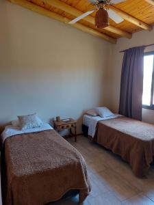 een slaapkamer met 2 bedden en een plafond bij Pequeña Polonia-Lodge & Cabañas in Los Reartes
