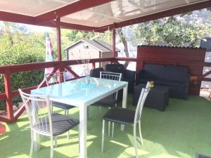 - une table et des chaises sur une terrasse avec un toit dans l'établissement Charmant mobil-home, à Rocbaron