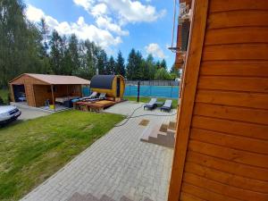 une cour avec une piscine et un kiosque dans l'établissement Dom NARIE na Mazurach nad Jeziorem Narie, à Bogaczewo