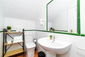 biała łazienka z umywalką i lustrem w obiekcie Home4u Casa del Tesoro I w Grenadzie +37 zdjęć