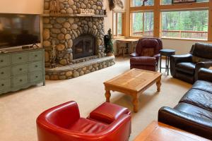 uma sala de estar com sofás e uma lareira de pedra em Snowpeak Tahoe Donner Golf Course Views em Truckee