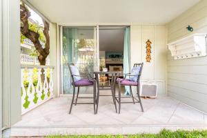 un patio con mesa y sillas en un porche en DOWNTOWN PARADISE GARDEN HOTEL CONDO with Hot Tub, Pool & Beach en Kailua-Kona