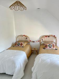 sypialnia z 2 łóżkami i żyrandolem w obiekcie Maison chaleureuse avec Jacuzzi w mieście Plouézec +2 zdjęcia