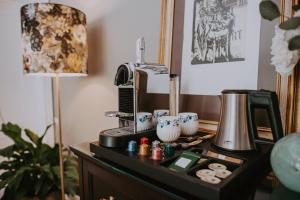 een bureau met een koffiezetapparaat en een lamp erop bij Villa Geva in Montignies-le-Tilleul