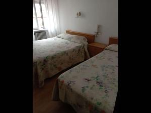 1 dormitorio con 2 camas y ventana en Room in Lodge - Pension Oria Luarca Asturias en Luarca