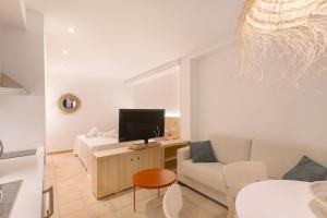 La Vila Hort by Seaward Suites في فايلاجويوسا: غرفة معيشة مع أريكة وتلفزيون