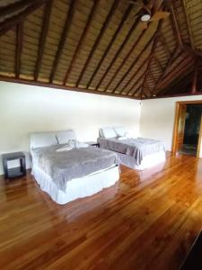 two beds in a room with a wooden floor at Cascadas Corcovado - luxury villa in Charcos