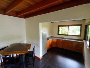 a kitchen with a table and a refrigerator at Cascadas Corcovado - luxury villa in Charcos