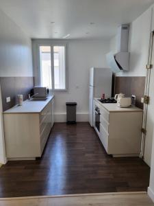 uma cozinha com balcões brancos e um frigorífico em Maison COSY à 4km BERCY ARENA 15mn PARIS gare 800m em Vitry-sur-Seine