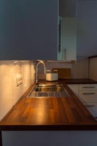 a kitchen with a wooden counter top with a sink at Tolle Stadtwohnung mit guter Verkehrsanbindung Von der Goltz 35 in Dortmund +4 photos